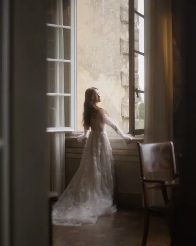 Bride in a château room with her bridal party cheering behind her.